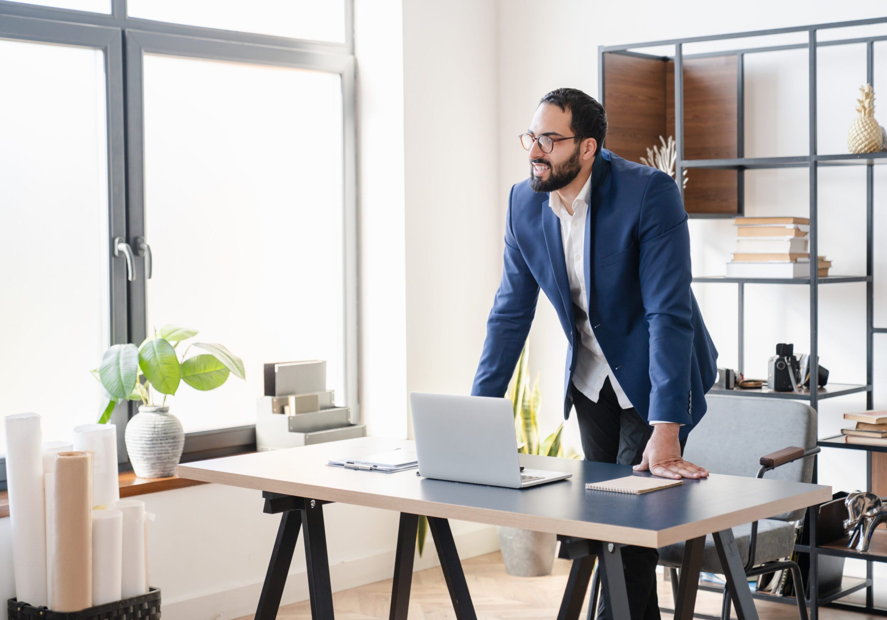 Thoughtful Middle Eastern successful businessman planning job deals, contracts, imagining huge success in working space at workplace in office. Remote job, boss freelancer